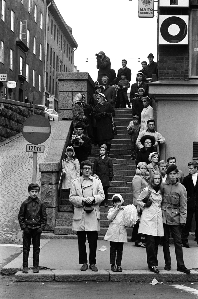 Ihmisiä seuraamassa työläisten vappumarssia Vuorikadun päässä olevilla portailla Kaisaniemenkadun kulmassa.