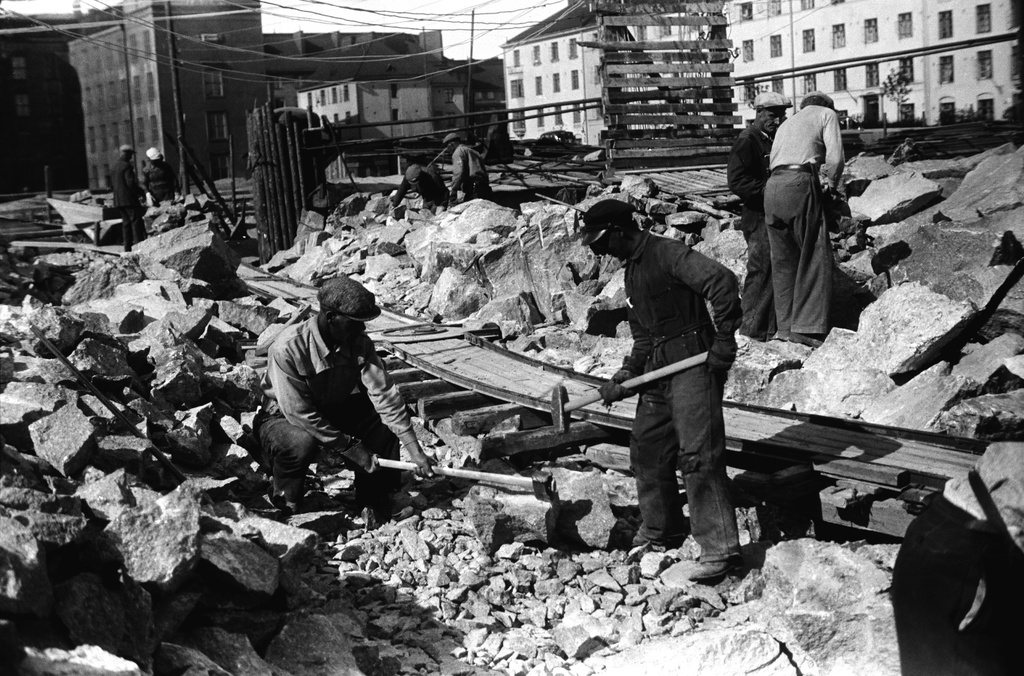 Maanrakennustöitä Torkkelinmäellä, todennäköisesti Helsingin toisen suomalaisen lyseon (nyk. Helsingin kuvataidelukio, ent. Torkkelin lukio) työmaa n. vuonna 1944. Taustalla Agricolankatu 1-3 pihan puoli sekä Torkkelinkatu 19, 17.