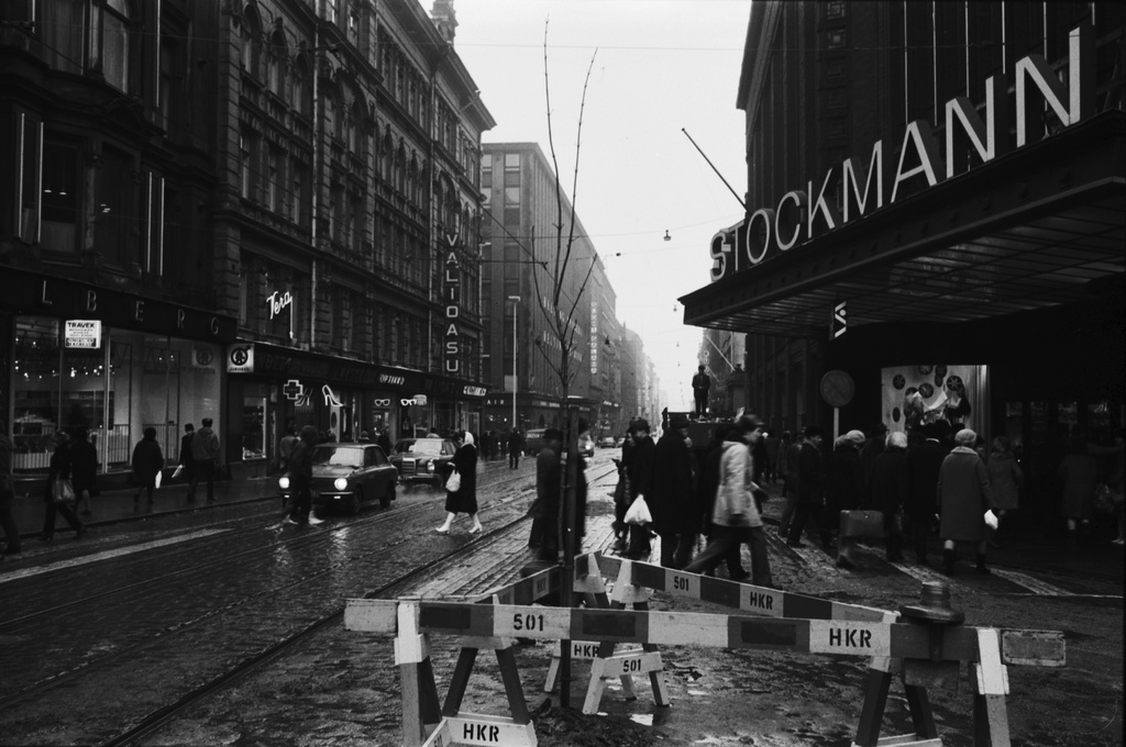 Kluuvi Aleksanterinkatu Puomien ympäröimä verivaahtera Stockmannin tavaratalon edustalla. Liikennepoliittinen yhdistys Enemmistö ry istutti puun Aleksanterinkadulle Helsinki-päivänä 12.6.1970, kävelykatukokeilun avajaispäivänä. Näkymä itään, Senaatintorin suuntaan.