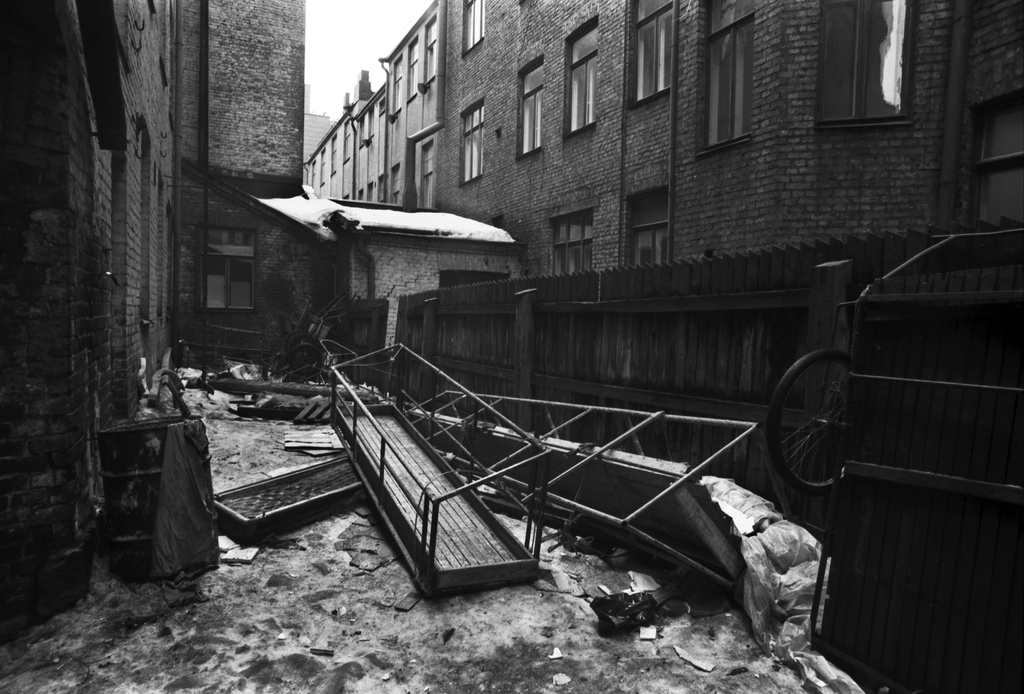 Fabianinkatu 8. Pari maalarinkelkkaa, torikärryt ja muuta tavaraa kerrostalojen välissä olevalla kapealla pihalla Fabianinkadulla. Näkymä etelään.