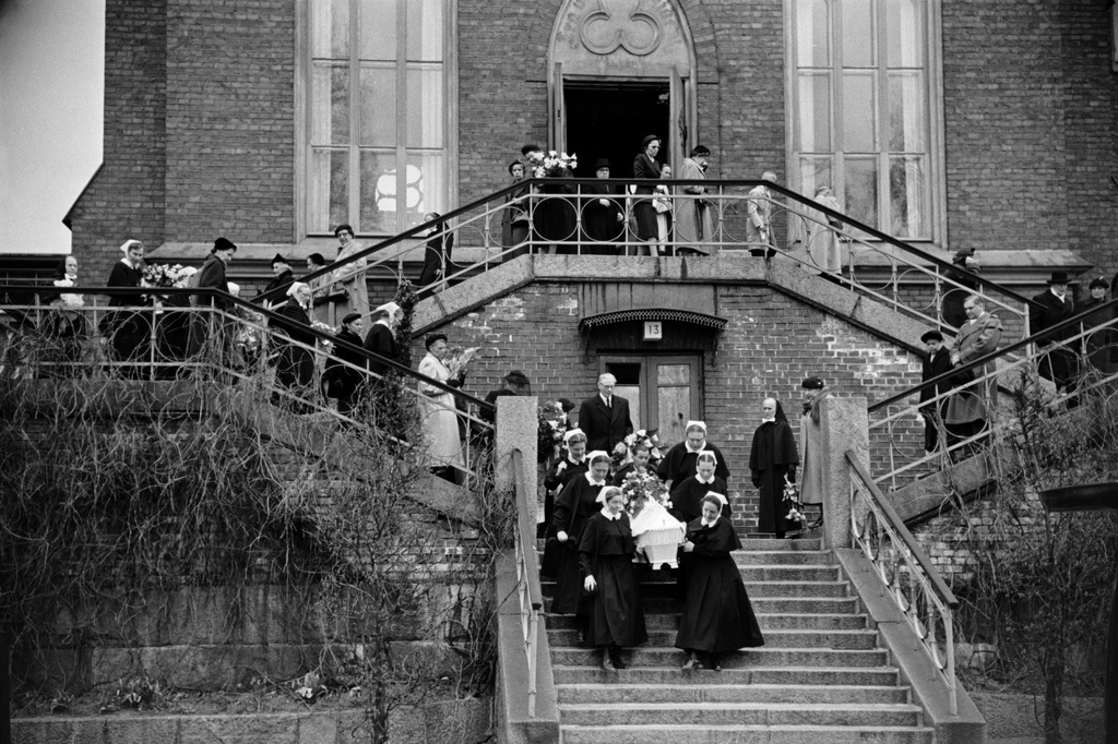 Helsingin Diakonissalaitoksen kirkko, Ester Svenssonin hautajaiset, hautasaatto. Diakonissat kantavat arkkua alas portaita kohti autoa.