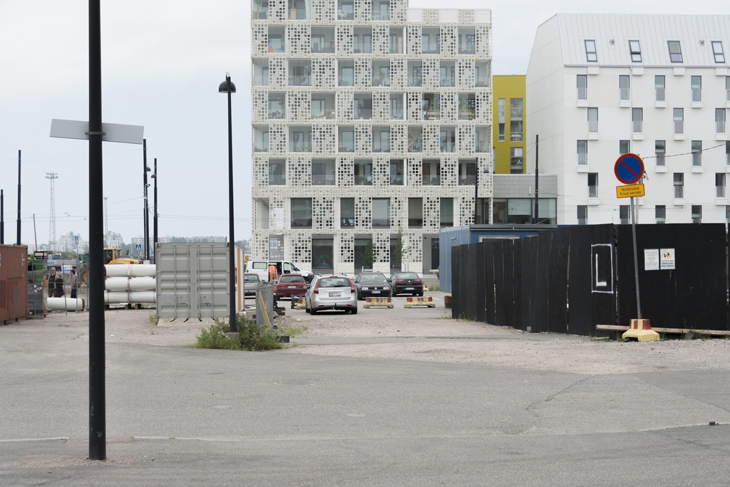 Jätkäsaaren dokumentointi. Länsisatamankatu 23 ja 21. Etualalla tilapäinen aukio, jossa kontteja, rakennusmateriaaleja ja työmaa-aitaa.