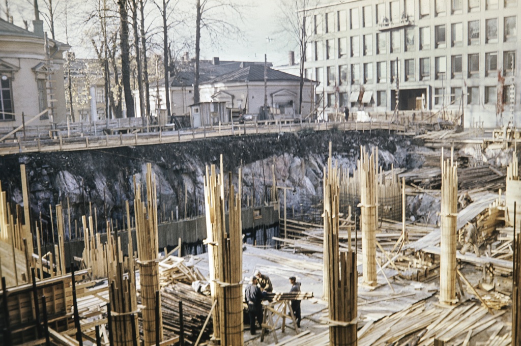 Suomen Pankin virastosiiven rakennustyömaa. Rauhankatu 16. Taustalla Carl Ludvig Engelin suunnittelema Pyhän kolminaisuuden kirkko, Unioninkatu 31. - Rauhankatu 18. Sekä Suomen Pankin setelipaino, Rauhankatu 19.