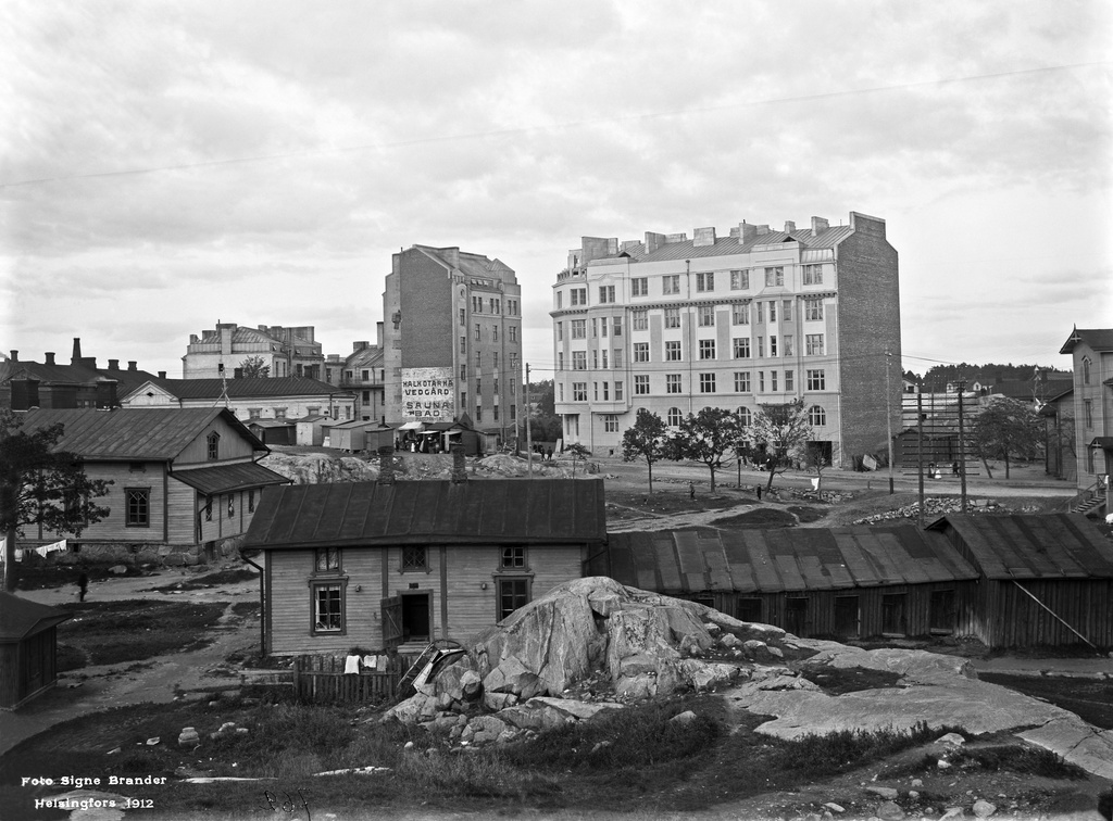 Etualalla Helsinginkatu 4. Takana matala vaalea kivitalo ja korkea kivitalo pääty kuvaan pain on Vaasankatu 5 - Pengerkatu 30 (= Kinaporinkatu 2). Kivitalo oikealla Vaasankatu 3 (= Vaasanpolku 3) - Pengerkatu 31 (= Kinaporinkatu 1)..