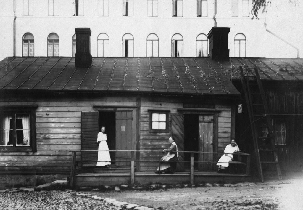 Kuuselan perheen naisväkeä kotitalon kuistilla Uudenmaankatu 26:ssa. Oikealla Selma Kuusela, keskellä äiti Charlotta Kuusela ja vasemmalla Martta Kuusela. Taustalla Uudenmaankatu 23 kivitalo.