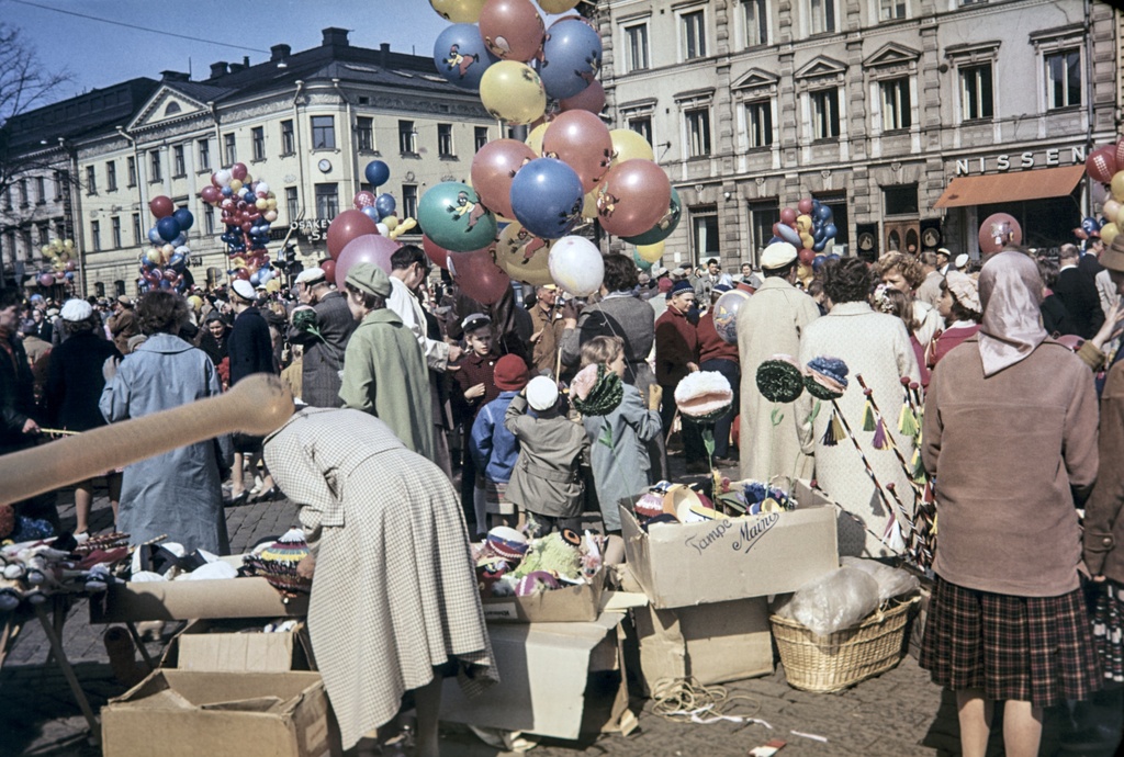 Ihmisiä Kauppatorin vapputorilla. Taustalla Pohjoisesplanadi 17 ja 19.