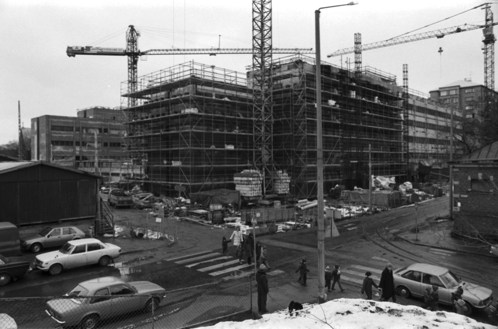 Ensi linja 3. Wallininkatu 2. Osittain rakennustelineiden peitossa oleva Suomen Kaupunkiliiton toimitalo (Kuntatalo) nostokurkien ympäröimänä. Näkymä Ensi linjan ja Eläintarhantien kulmassa olevilta kallioilta pohjoiseen.