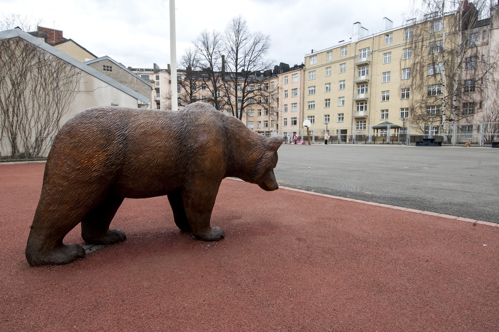 Töölön ala-asteen pihan veistokset. Etualalla on karhu ja taaempana aidan vieressä näkyy kettu.