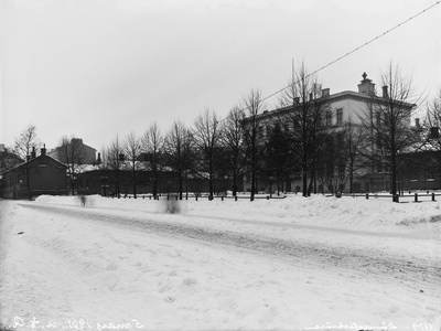 Talvinen näkymä Antinkadulta (=Lönnrotinkatu), Vanhan kirkon edestä luoteeseen kohti Kirkkotoria (=Lönnrotin puistikko), keskellä Helsingin Suomalaisen Reaalilyseon (nyk. Ressun lukio) rakennus.  duplicate photo