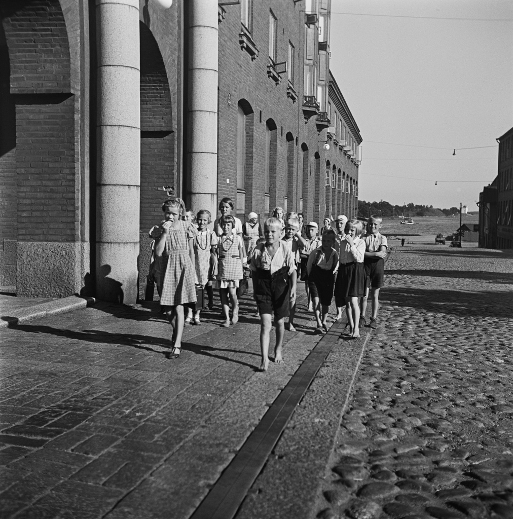 Sompasaaresta palaavia lapsia Elannon hallintorakennuksen edessä. (Elannolla oli saaressa kesäsiirtola työntekijöidensä lapsille.) Kaikukatu 2 (-Hämeentie 11-13).
