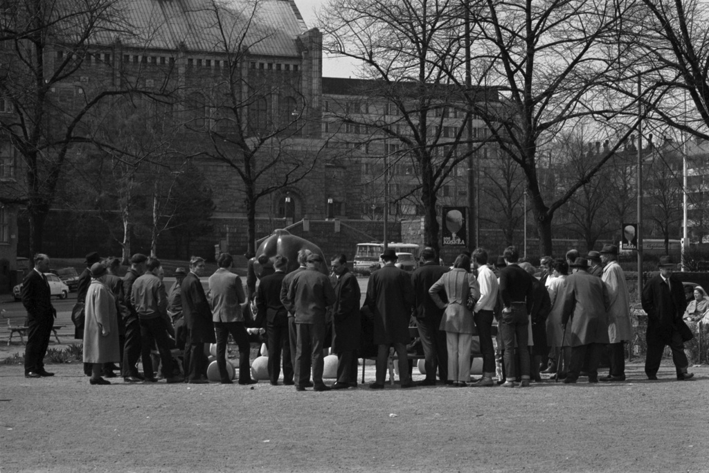 Karhupuisto. Ihmisiä suuren shakkilaudan ympärillä Karhupuistossa. Taustalla vasemmalla Kallion kirkko.
