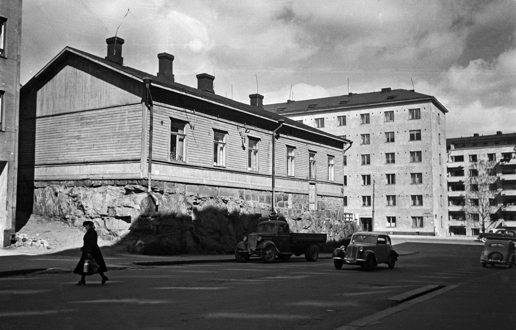 Matala puutalo Mannerheimintien ja Päivärinnankadun risteyksessä, osoitteessa Mannerheimintie 102. Taustalla näkyy Mannerheimintie 49, jonka takana Urheilukatu 40 sisäpihalta nähtynä.