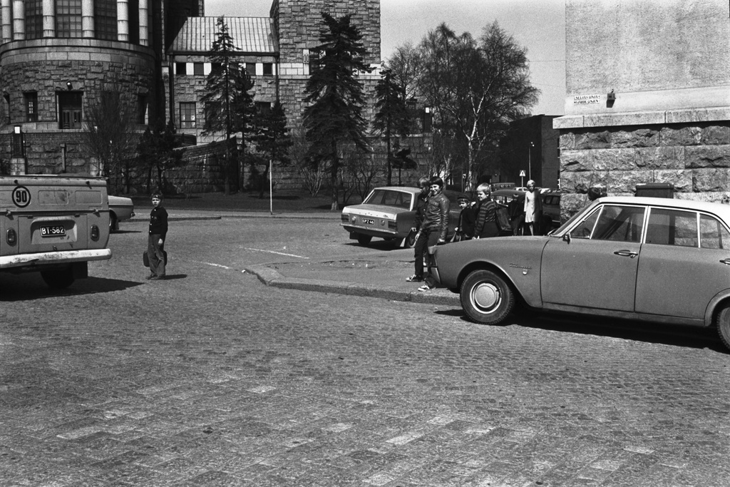 Neljäs linja 15. Itäinen Papin katu. Koululaisia ylittämässä katua Kallion kansakoulun kulmalla Neljän linjan ja Itäisen Papinkadun risteyksessä. Kadun laidalla oikealla Ford Taunus. Taustalla Kallion kirkko.