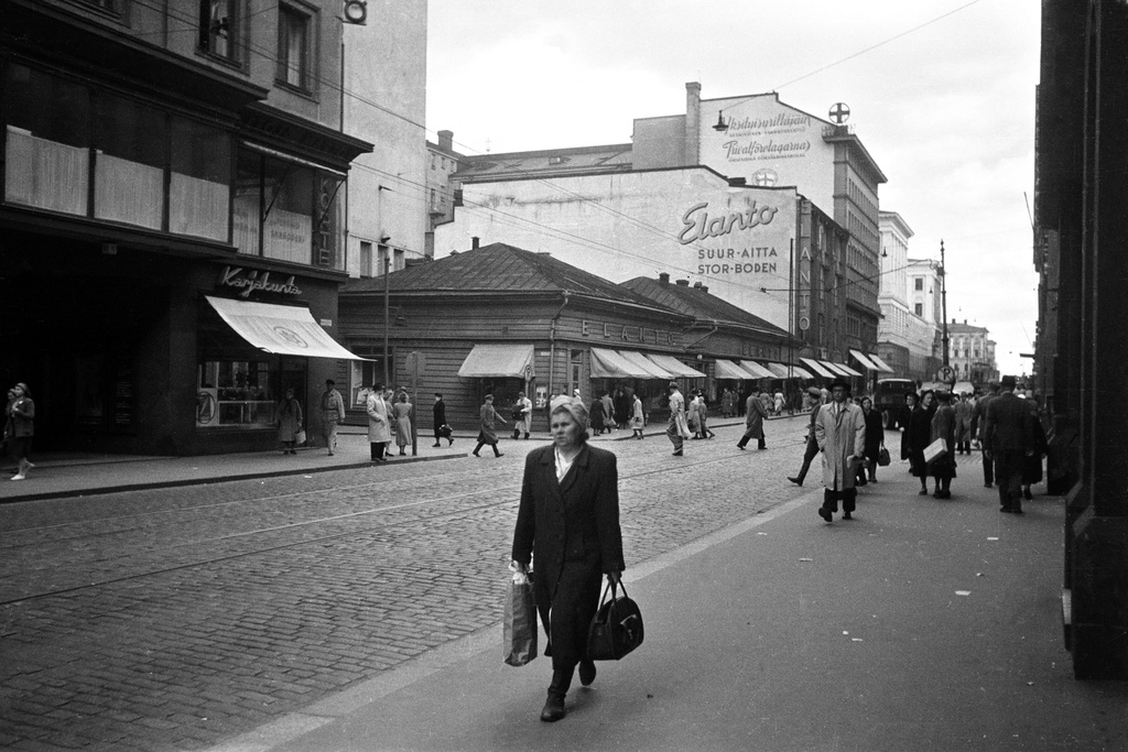 Aleksanterinkatu 11 - 7. - Kluuvikatu 5. Näkymä Aleksanterinkatua itään. Karjakunta -myymälä, Elannon myymälä ja Elannon suur-aitta. Puurakennukset purettiin syksyllä 1950 ja paikalle rakennettiin Elannon tavaratalo.