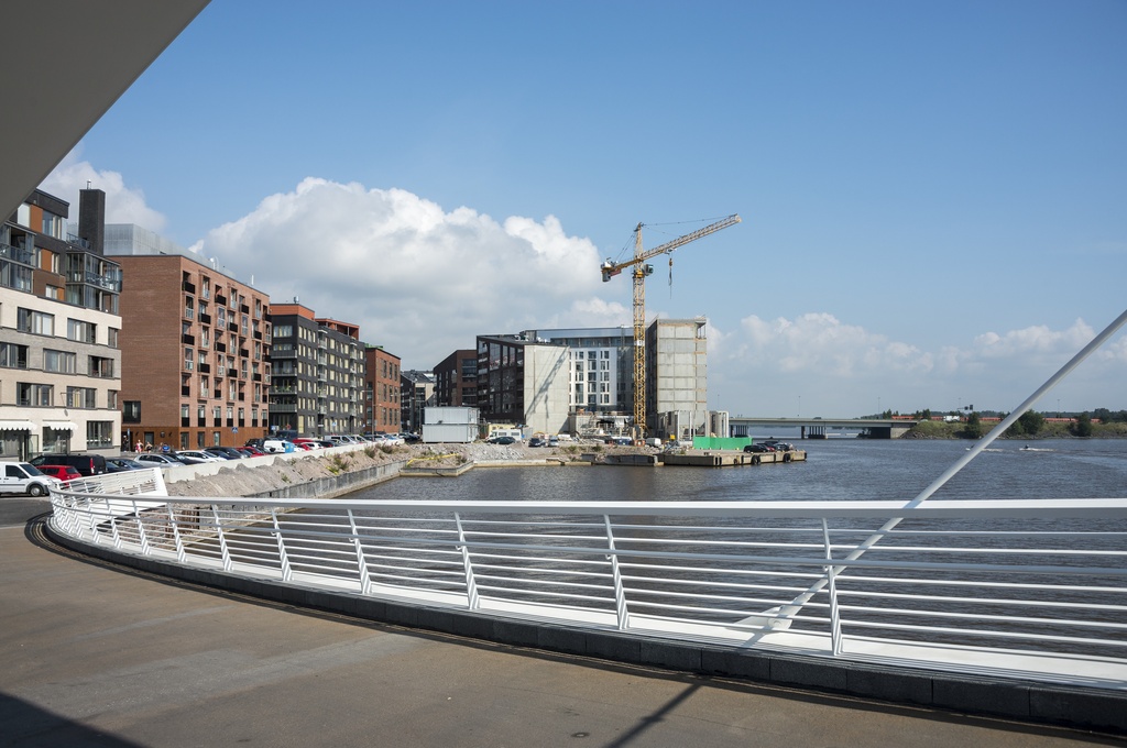 Kalasataman dokumentointi. Capellan puistotie, Sörnäistenlaituri, Kalasataman uutta rakennuskantaa, Isoisänlaituri. Taustalla Kulosaaren silta ja metrojuna.