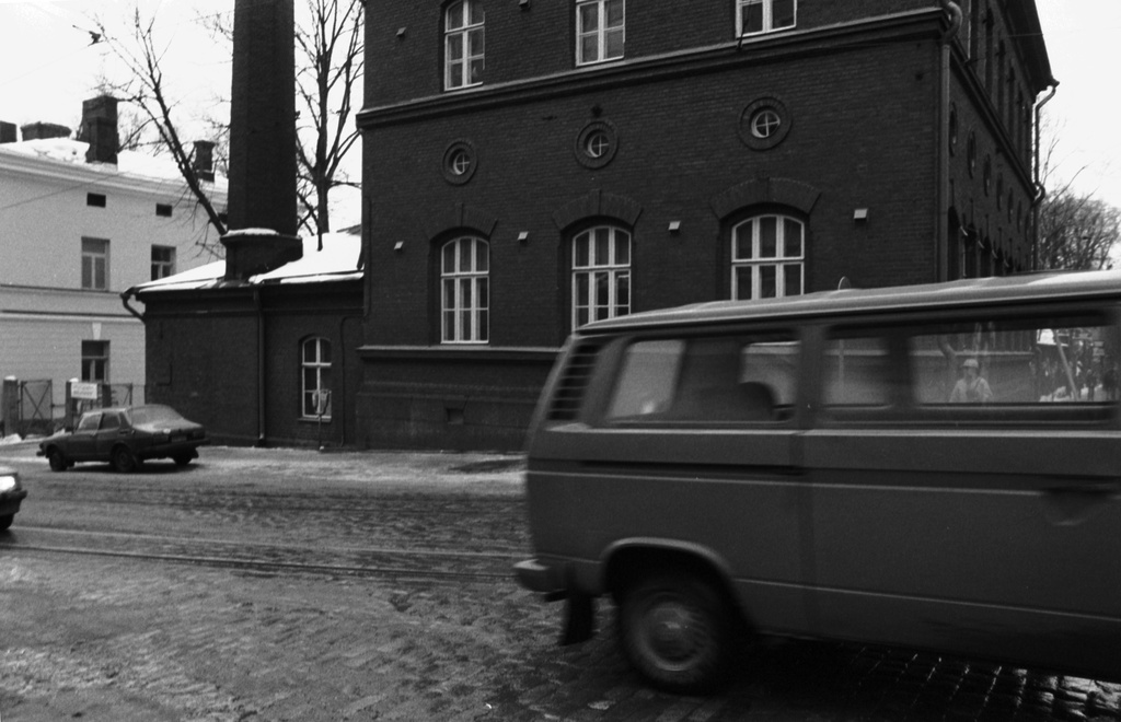 Liisankatu 20. Liisankatu 20:n talo Snellmaninkadun kulmassa. Etualalla ohi ajava auto.