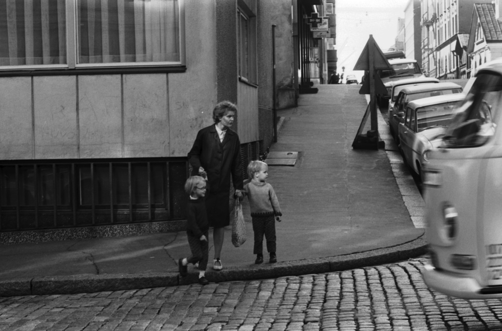 Liisankatu 4. Nainen kahden lapsen kanssa ylittämässä Liisankatua Meritullinkadun kulmassa.