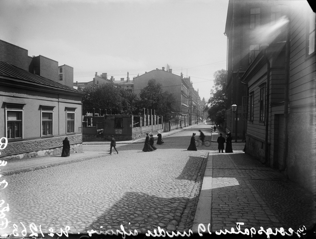 Näkymä Yrjönkatua pitkin kaakkoon, vasemmalla Yrjönkatu 21, 19, 17, 15, oikealla 26, 24. Keskellä kulkeva poikkikatu on Vladimirinkatu (=Kalevankatu).