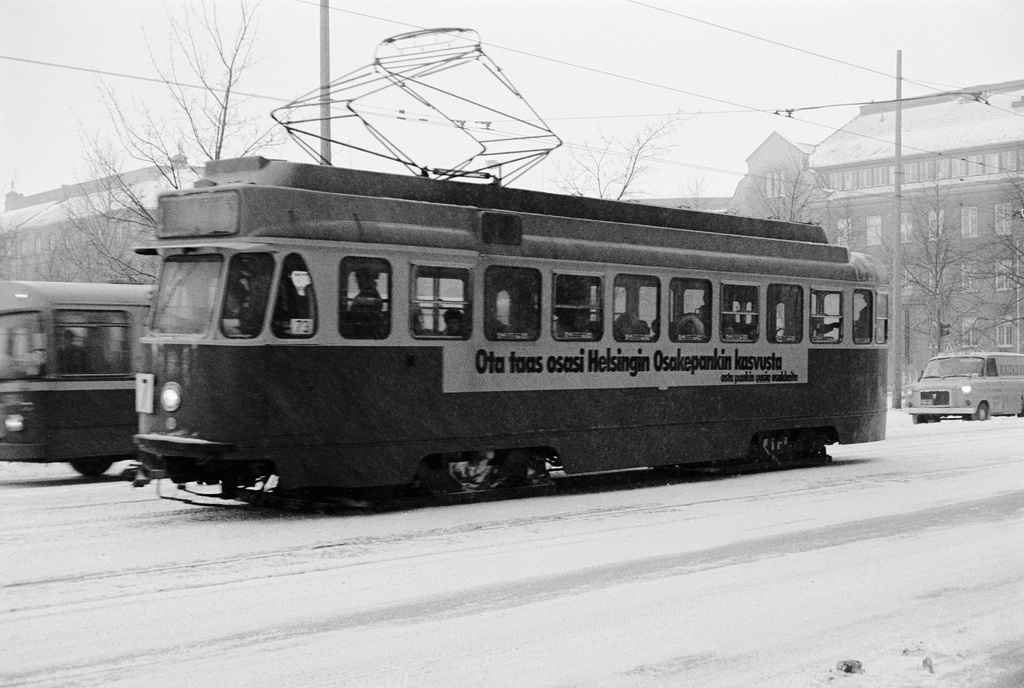 Ensilumi Töölössä vuonna 1973. Liikennettä Runeberginkadulla. Raitiovaunu etualalla, taustalla näkyy entinen Tyttönormaalilyseo, vuodesta 1969 Kauppakorkeakoulun Chydenia.