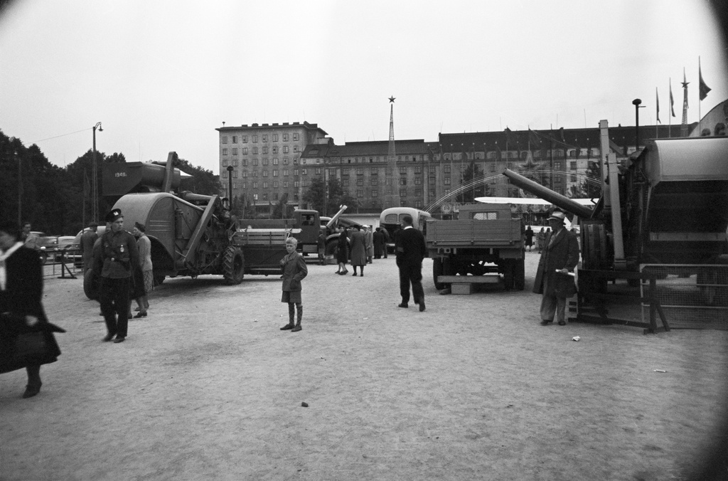 Neuvostoliiton teollisuusnäyttely Messuhallissa(=Töölön kisahalli) 29.5.-13.6.1948. Maatalouskoneita ym. esillä Messukentällä(=Mäntymäenkenttä). Vasemmalla kävelee poliisimies. Taustalla Mannerheimintie 58, 60, 62.