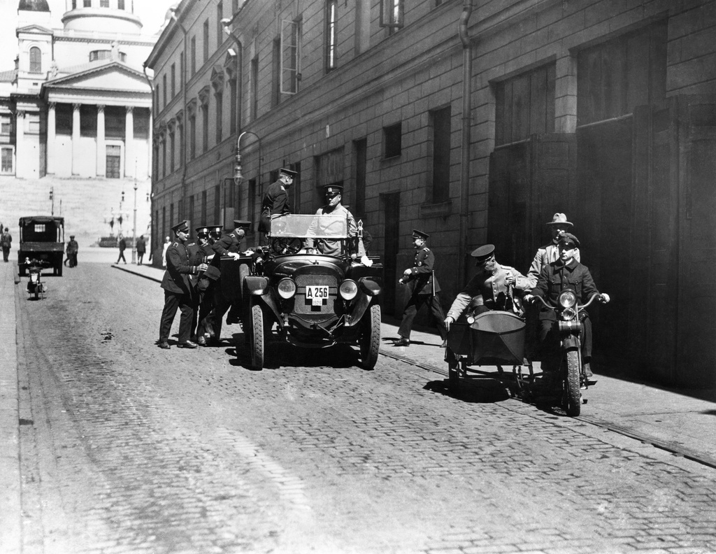 Poliiseja poliisilaitoksen edustalla, Sofiankatu 3. Moottoripyörä on Harley Davidson.