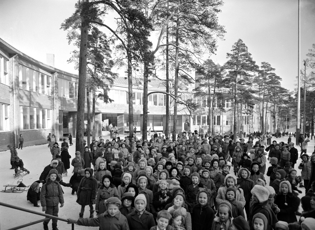 Lapsia uuden Meilahden kansakoulun pihalla. Rakennuksen olivat suunnitelleet arkkitehdit Osmo Sipari ja Viljo Revell (ko kohteen arkkitehtikilpailun voittajat), kaarevarunkoinen koulu rakennettiin vuosina 1949-1953.