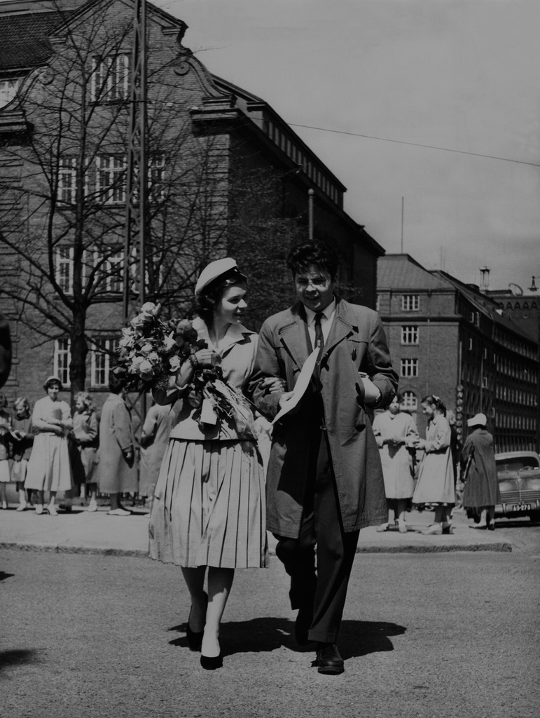 Tyttönormaalilyseon ylioppilas kavaljeerinsa kanssa. Lakkiaispäivä Runeberginkadulla Töölössä. Elanto-lehden kuva.