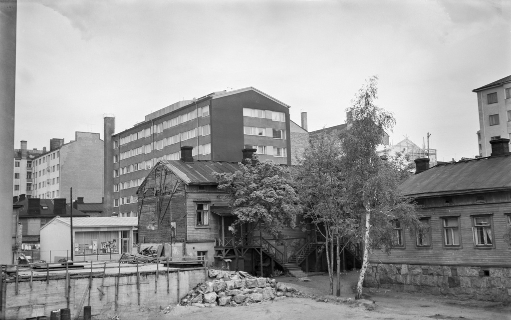 Näkymä sisäpihalta kohti korttelin kulmaa Castréninkatu 1 C - Kolmas linja 26. Taustalla kohoava asuinkerrostalo on Castréninkatu 8 ja 10. Oikealla näkyy kulma talosta Kolmas linja 27. Etualan puutalot kuuluvat Työväen asunto-osakeyhtiö Askelen rakennuksiin, jotka hallitsivat korttelin Castréninkadun puoleista laitaa