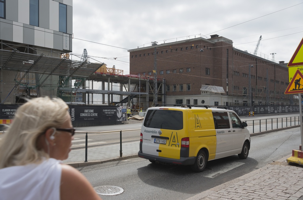 Jätkäsaaren dokumentointi. Tyynenmerenkatu, Hotelli Clarionin rakennustyömaa, Sonckin makasiinista tulee hotellin kongressikeskus. Etualalla nainen selin ja pakettiauto.