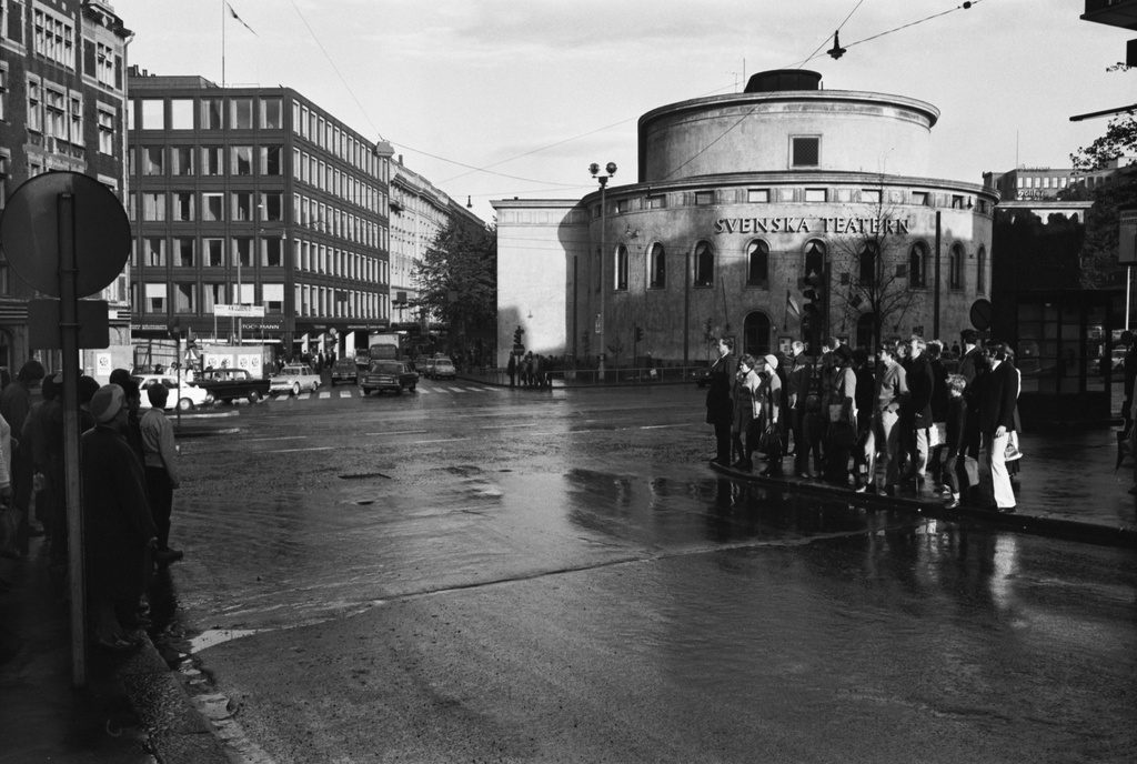 Mannerheimintie. Pohjoisesplanadi 2. Jalankulkijoita odottamassa liikennevalon vaihtumista Lönnrotinkadun ja Mannerheimintien kulmassa. Näkymä Pohjoisesplanadin suuntaan. Oikealla Ruotsalainen teatteri.