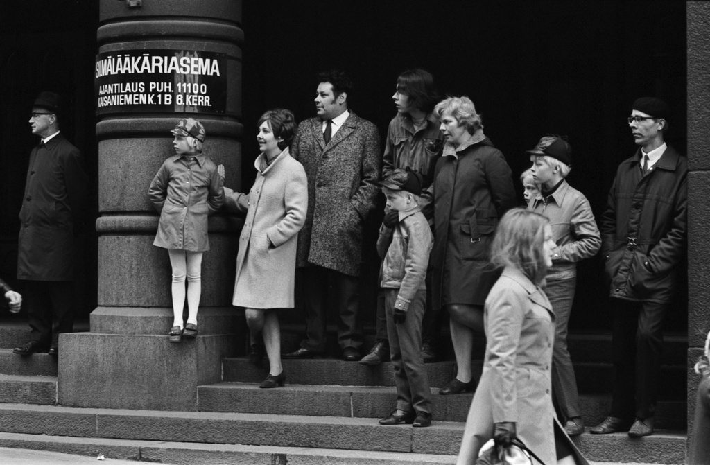Kaisaniemenkatu 1. Ihmisiä seuraamassa työväen vappumarssia Kaisaniemenkatu 1:n portailta 1.5.1970.