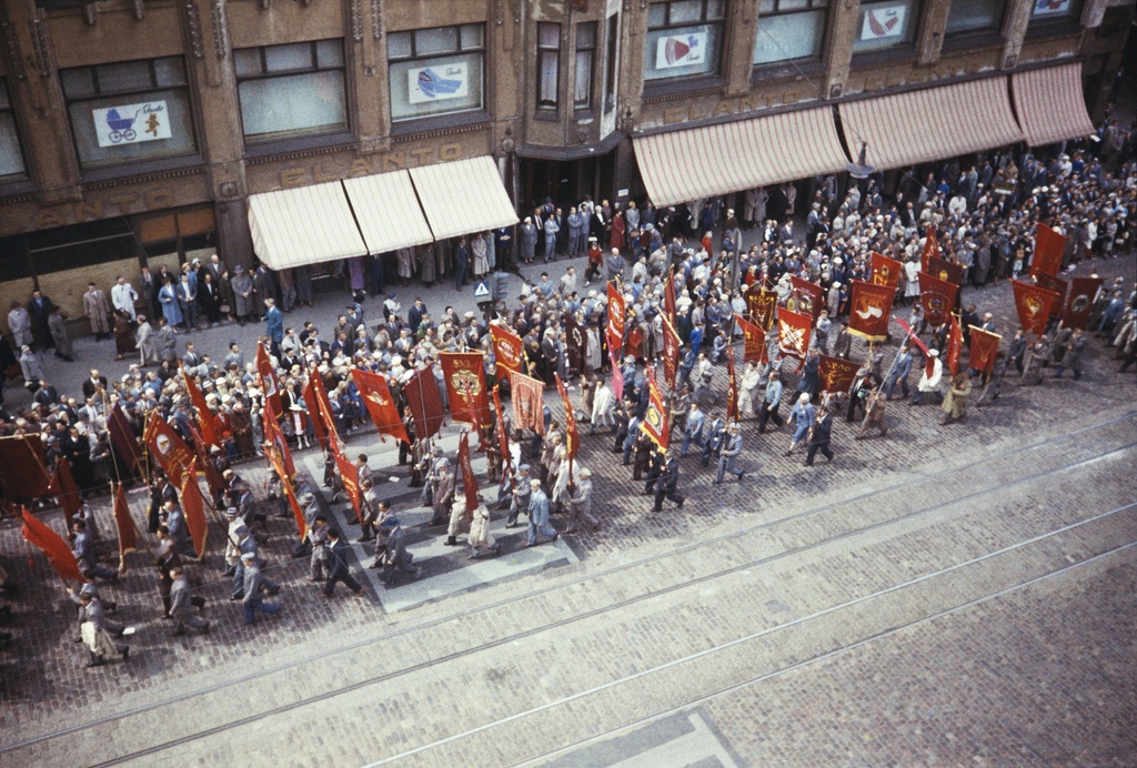Elanto. Elanto-lehti N:o 12-13, 1957. Helluntai 1957. Valtakunnallisen ammattiyhdistyslikkeen 50-vuotisjuhla. Kulkue Hakaniemessä Elannon edessä. Juhlakulkue marssi ammattiyhdistysliikkeiden lippujen johtamana viisitoistatuhantisena, juhlavana rivistönä läpi Helsingin. Pääjuhla pidettiin stadionilla.