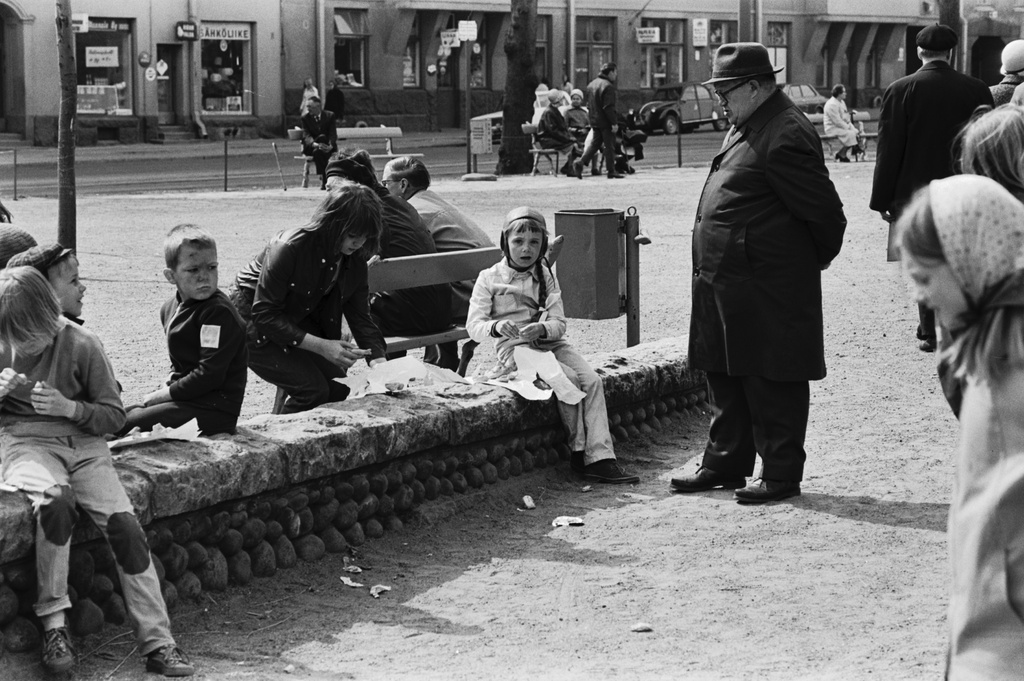 Karhupuisto. Mies katselemassa Karhupuiston kiviaidalla puistotapahtuman savityöpajassa muovailevia lapsia.