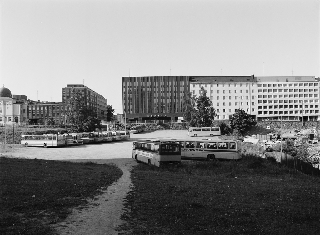 Linja-autojen pysäköintoalue Kampin kolmiossa, Runeberginkadun ja Malminkadun välissä.  Taustalla Malminkatu 28, 30, 32, 34.