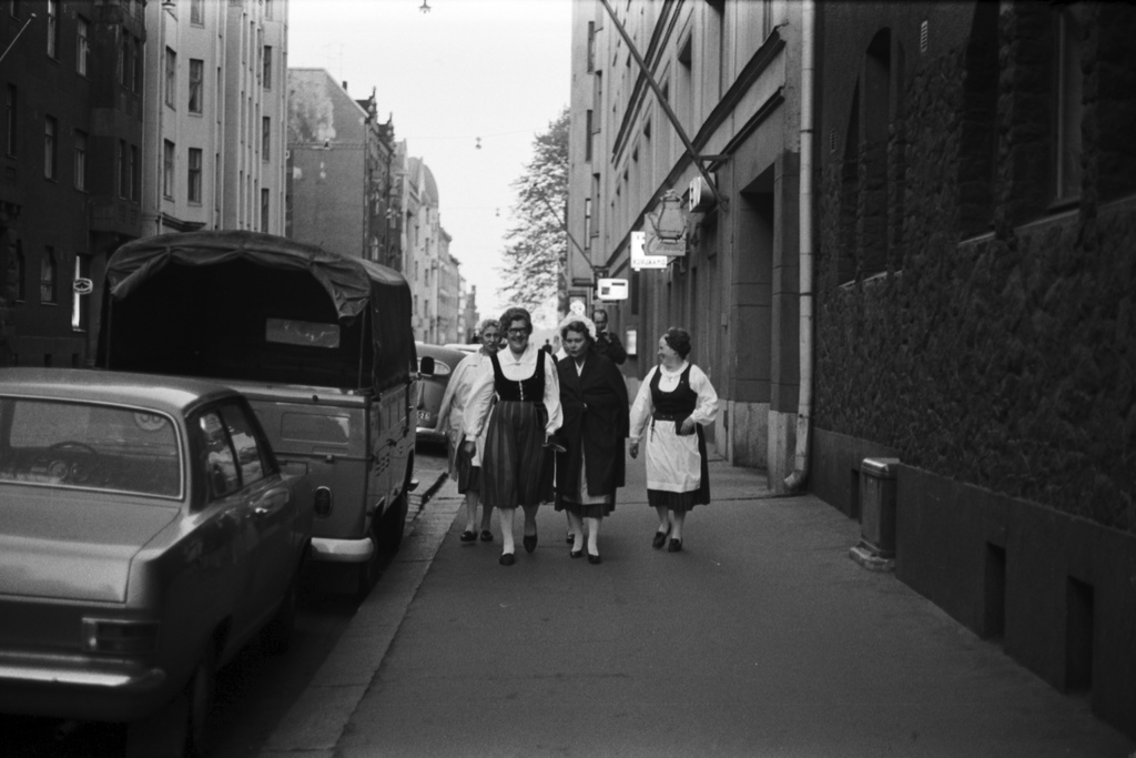 Liisankatu 16. Kansallispukuihin pukeutuneita naisia kävelemässä jalkakäytävällä. Näkymä Liisankatu 16:n edustalta itään Mariankadun suuntaan.
