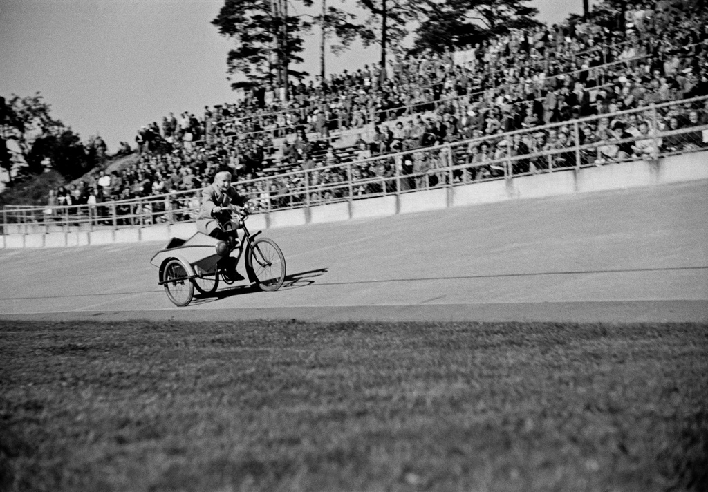 Velodrom, Helsingin pyöräilystadion, moottoripyöräkilpailut. Poika polkee radalla sivuvaunullisella, moottoripyörän näköiseksi rakennetulla polkupyörällä.
