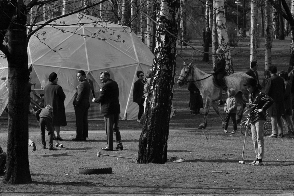 Sibeliuksen puisto. Helsingin juhlaviikot. Ihmisiä puistotapahtumassa keväisessä Sibeliuksen puistossa. Ohjelmassa poniratsastusta ja kroketinpeluuta. Taustalla puolipallon muotoinen muovikupu.