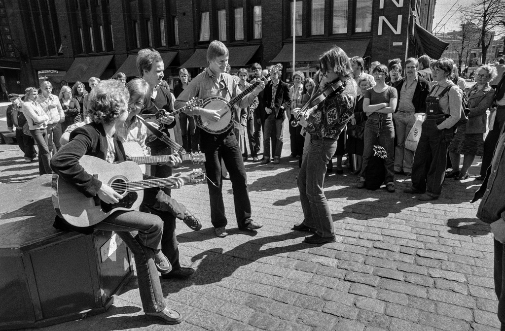 Elävän musiikin yhdistys Elmu ry:n katusoittotapahtuma Kolmen sepän aukiolla. Elmu kampanjoi tapahtumalla katusoiton vapauttamisen ja julkisen tilan käytön joustavuuden puolesta. Yleisöä katusoittajien ympärillä.