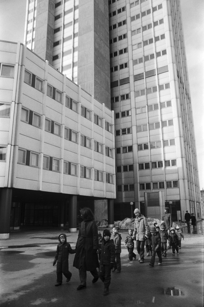 Vironniemen päiväkodin lapsia ja aikuisia kävelemässä aukiolla saavuttuaan tutustumaan Merihakaan. Taustalla Haapaniemenkatu 9:n 17-kerroksinen tornitalo.