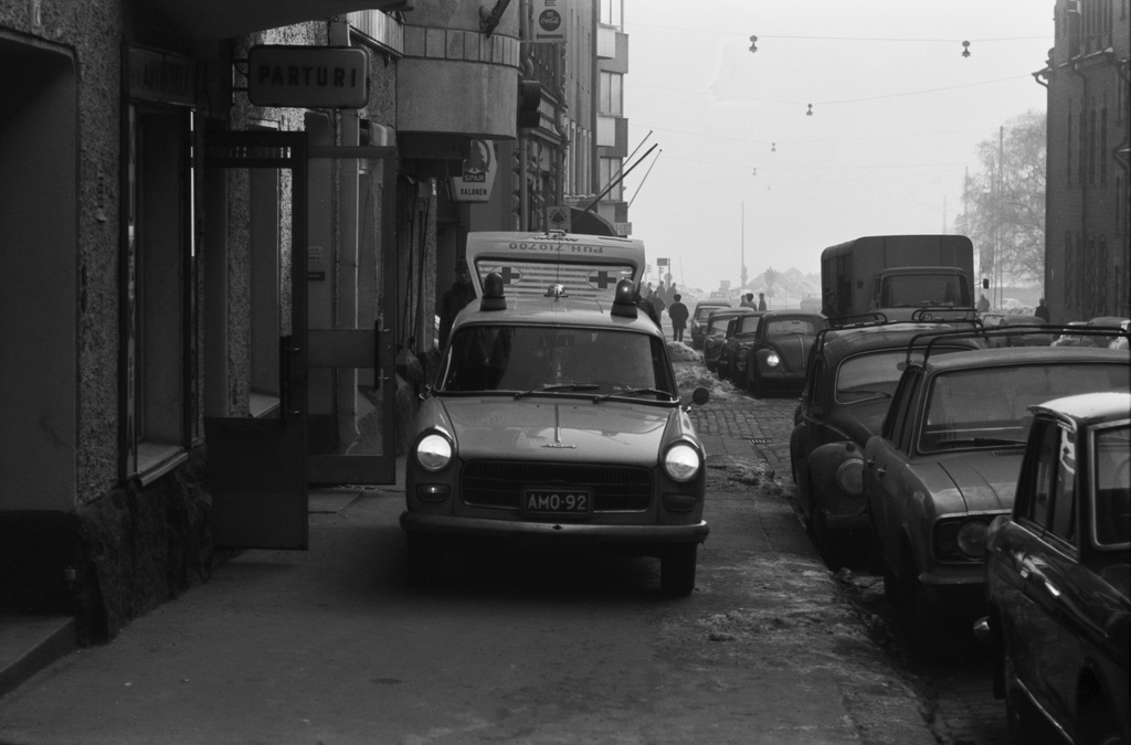 Liisankatu 9. Yksityisen sairaankuljetusyrityksen Peugeot-merkkinen ambulanssi jalkakäytävällä Liisankatu 9:n edustalla. Näkymä Meritullinkadun suuntaan.