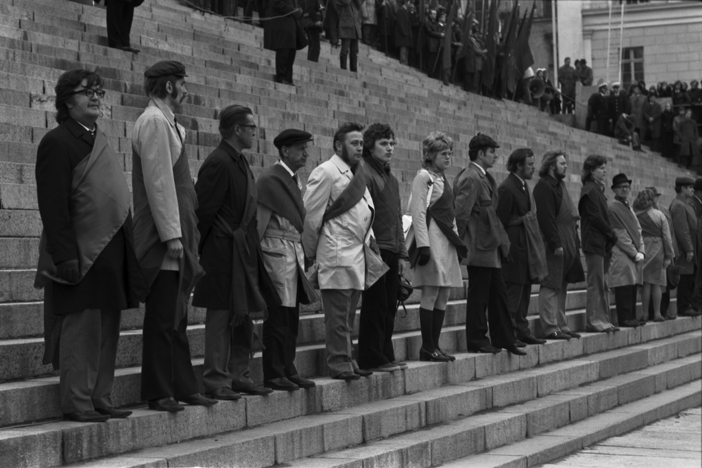 Hallituskatu 7. Ihmisiä, joilla airutnauhat seisomassa Tuomiokirkon alaportailla työväen vappujuhlassa 1.5.1972. Yläportailla ihmisiä lippujen kanssa.