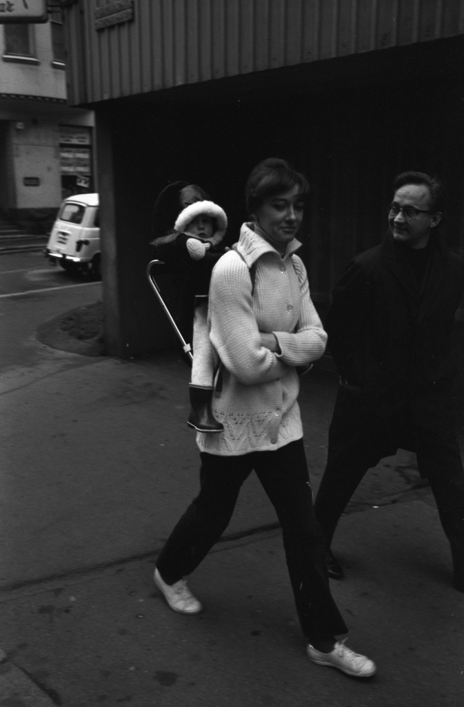 Punavuori, Perämiehenkatu 5. Mies ja nainen kantotelineessä oleva lapsi selässään Perämiehenkadulla Pursimiehenkadun kulmassa.