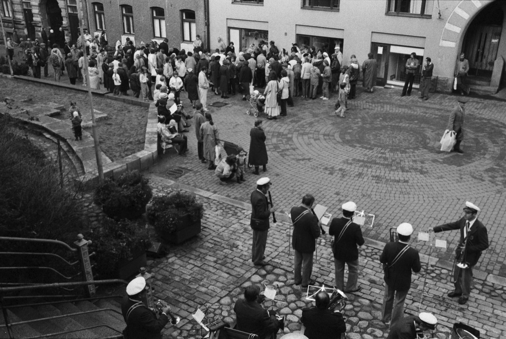 Oikokatu. Asukastapahtuma Oikokadun pihakadulla. Ihmisiä kerääntyneenä Oikokatu 9:n ja 11:n edustalla olevien kirpputoripöytien ääreen. Etualalla puhallinorkesteri aloittamassa musisointiaan. Kuvattu Siltavuorenpenkereeltä.