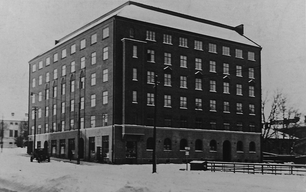 Runeberginkatu 56 - Ruusulankatu 2. Rakennus valmistui syksyllä 1926 korttelin ensimmäisenä kivitalona. Rakennuksen suunnitteli vastavalmistunut arkkitehti Gustaf Strandberg (1898-1953), joka asettui itsekin asumaan taloon.