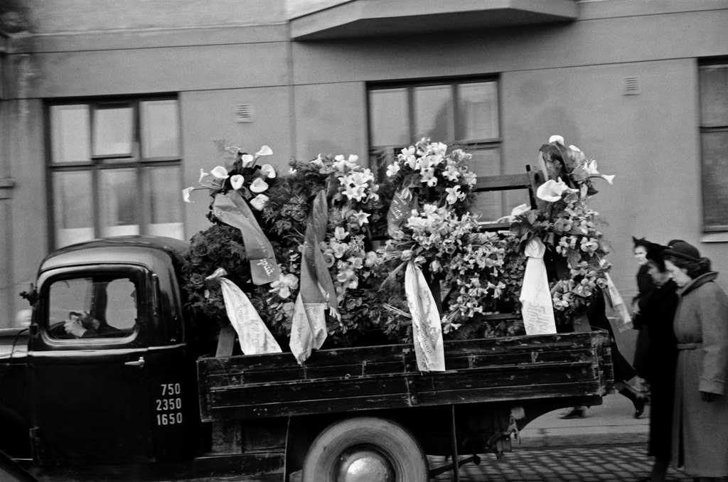 Miina Sillanpään hautajaiset, hautasaatto Lapinlahdenkatu 11:n kohdalla, hautaseppeleitä kuljettava auto.