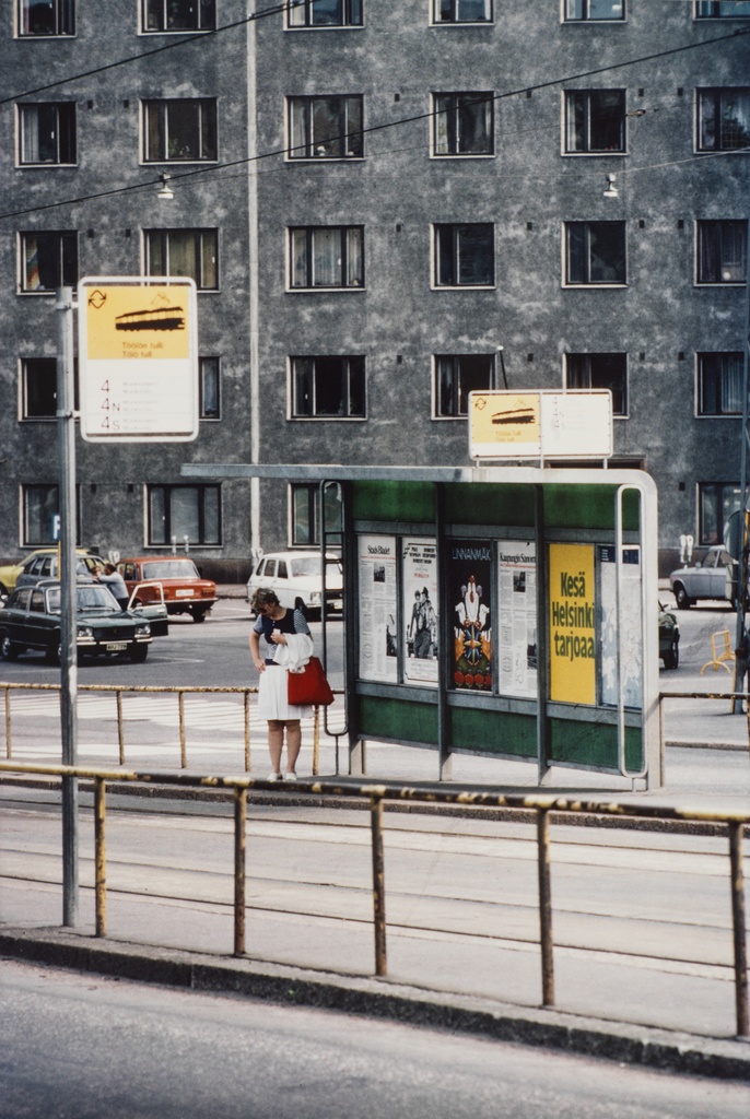 Nainen Töölön tullin raitiovaunupysäkillä. Pysäkillä pysähtyivät linjat 4, 4N ja 4S.