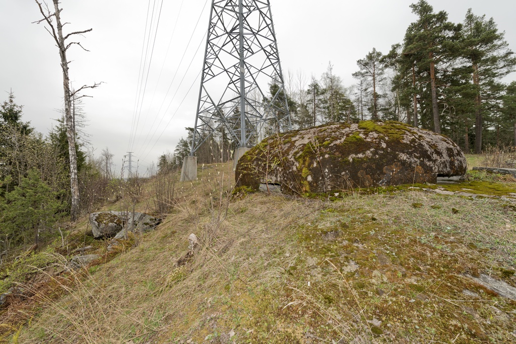 Ruukinranta. Ensimmäisen maailmansodan aikainen maalinnoitus, puolustusasema XXXVI:1 Ruukinrannassa, Espoossa. Kuvassa on linnoitteen länsipäässä sijaitseva soikea, kupukattoinen kivääri- tai tähystysasema. Betonista tehdyn rakenteen kyljissä näkyy kaksi aseman kolmesta tähystys- tai ampuma-aukosta. Rakenteen yli kulkee sähkönsiirtoon liittyvä voimalinja, jonka voimajohtopylväistä yksi sijaitsee aivan aseman vieressä. Kuvaussuunta itään.