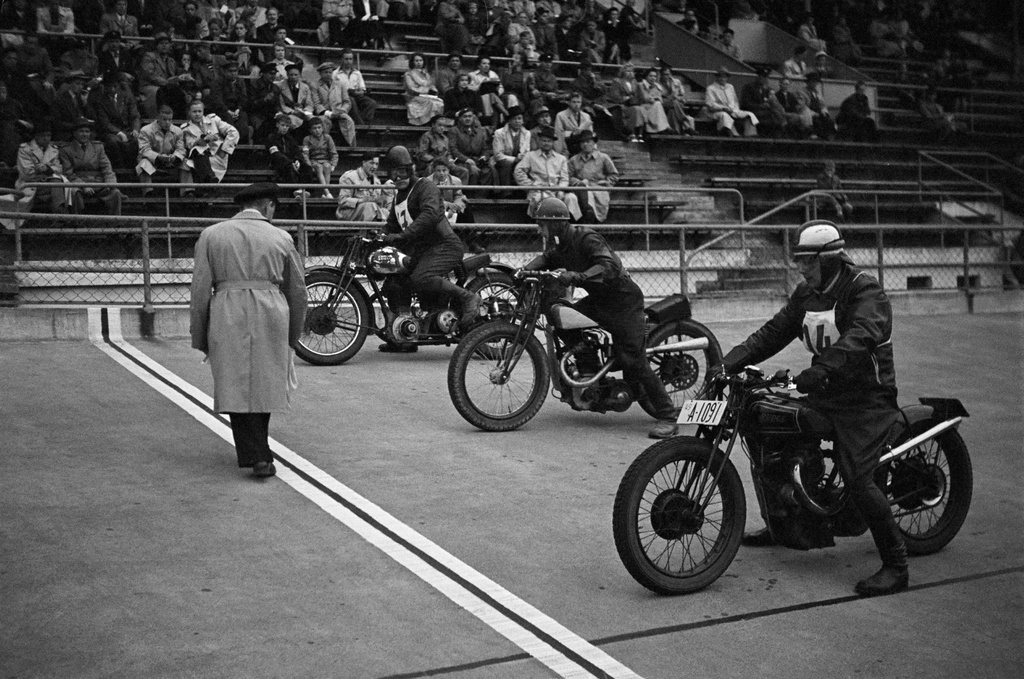 Velodrom, Helsingin pyöräilystadion, moottoripyöräkilpailut. Kolme kilpailijaa ja toimitsija lähdössä, taustalla katsomo ja yleisöä.