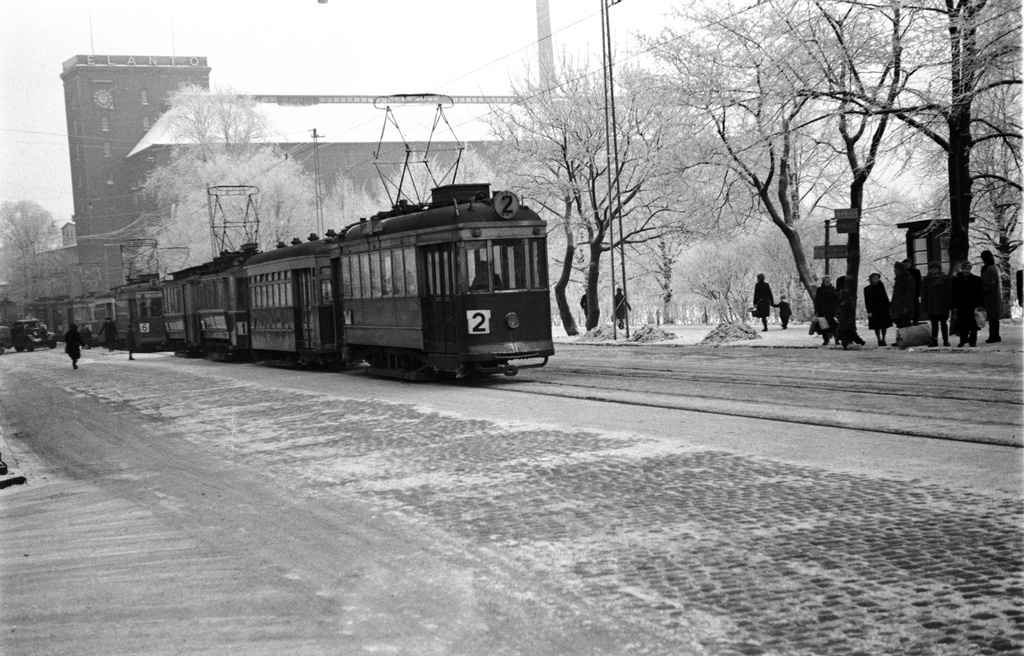 Raitiovaunuja jonossa Hämeentiellä Haapaniemen kentän (Väinö Tannerin kentän) kohdalla. Taustalla Elannon pääkonttori Hämeentie 11. - Kaikukatu 2.