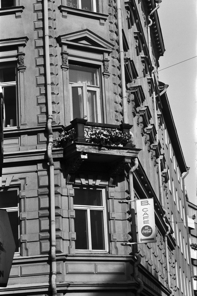 Liisankatu 7. Liisankatu 7:n kolmannen kerroksen kulmahuoneiston parveke kukkalaatikoineen Meritullinkadun kulmassa. Parvekkeen alapuolella B.Cafén kyltti.